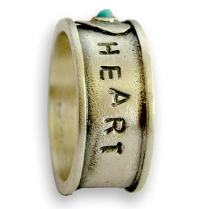 May include: A silver ring with a turquoise stone and the word "HEART" engraved on the band.
