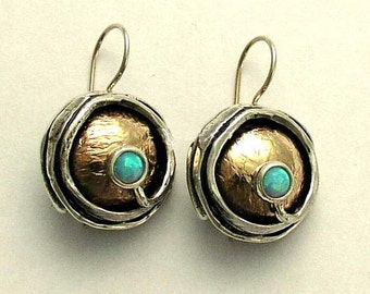 May include: A pair of silver earrings with a textured, hammered copper center and a small blue opal stone.