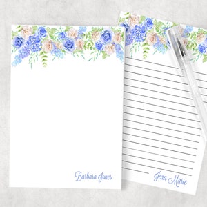 May include: Two white stationery note cards with blue floral borders. The top card has the name "Barbara Jones" written in blue ink at the bottom. The bottom card has the name "Jean Marie" written in blue ink at the bottom.