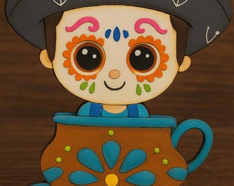 May include: A wooden decorative figurine featuring a stylized figure in a sombrero, with a painted face and a cup design. The figure has a painted face with floral accents and is set in a brown and blue cup.