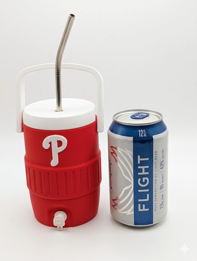 May include: A red and white plastic beverage cooler with a white handle, a white lid, a white spigot, and a metal straw inserted through the top. Next to it stands a silver and blue 12 fl oz aluminum can labeled Flight Next Generation of Light Beer.
