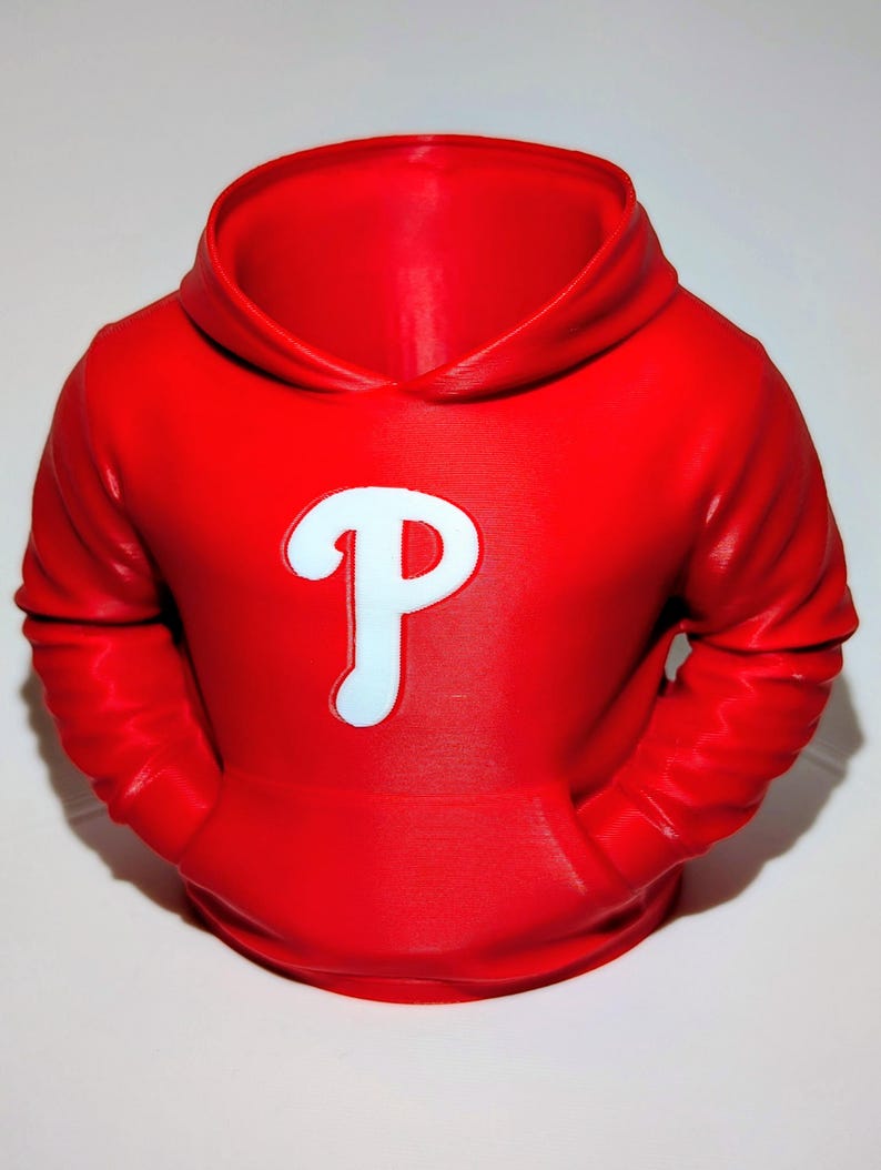 May include: A red hoodie with a white "P" logo on the front. The hoodie has a hood, a front pocket, and long sleeves. The logo is outlined in a light blue color.