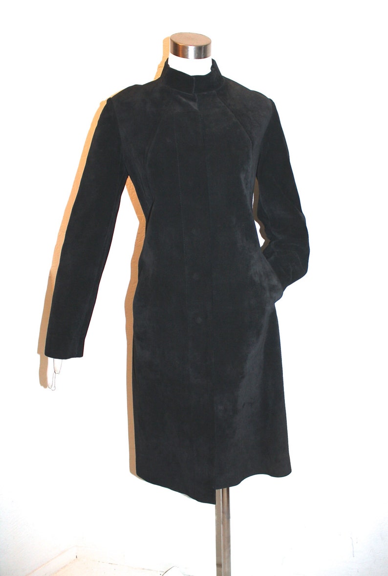 May include: A black long-sleeved mock neck jacket with a zipper closure and pockets.