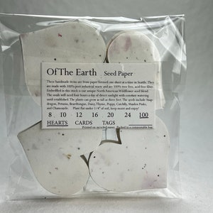 以下が含まれることがあります： 前面に「Of The Earth Seed Paper」と印刷された白いハート型の種紙の包装。パッケージには、8、10、12、16、20、24、100個のハートが含まれています。