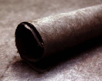 May include: A close-up of a rolled-up piece of brown paper with a textured surface.