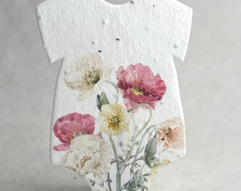 May include: A white, textured, seed-paper cutout shaped like a baby bodysuit, featuring a printed watercolor illustration of various poppies in shades of pink, cream, and yellow with green stems and leaves across the front surface.