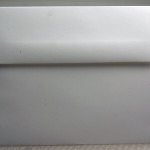 May include: A white envelope with a slightly textured surface.