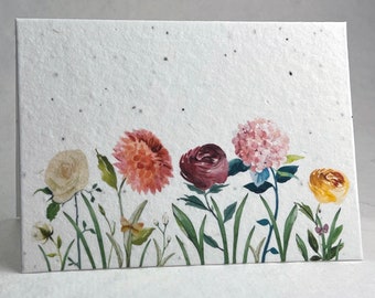 May include: A white card with a watercolor illustration of five flowers. The flowers are a white rose, a red rose, a pink hydrangea, a yellow flower, and a red and orange dahlia. The flowers are all on green stems and leaves.