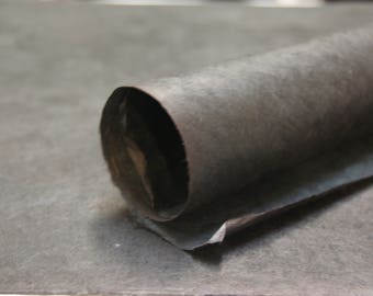 May include: A rolled up piece of dark brown paper with a rough texture.