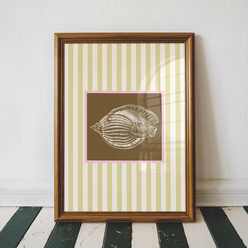 a green and white striped poster has a brown square with a pink border. In the square is a vintage white conch seashell image. The print is minimalist, beachy, with an east coast aesthetic. Great for bedroom or bathroom decor.