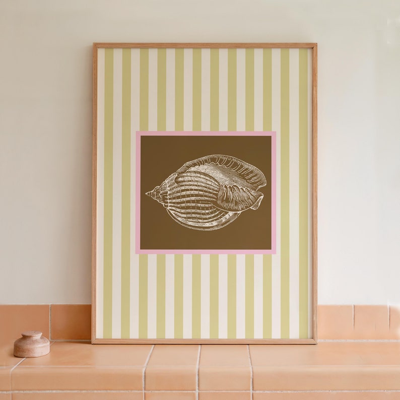 a green and white striped poster has a brown square with a pink border. In the square is a vintage white conch seashell image. The print is minimalist, beachy, with an east coast aesthetic. Great for bedroom or bathroom decor.