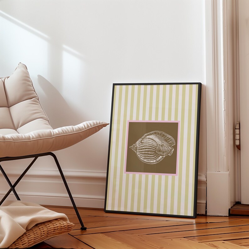 a green and white striped poster has a brown square with a pink border. In the square is a vintage white conch seashell image. The print is minimalist, beachy, with an east coast aesthetic. Great for bedroom or bathroom decor.