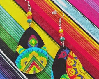 May include: A pair of teardrop-shaped earrings featuring a black base with vibrant, multi-colored geometric patterns in yellow, green, blue, and red. Each earring hangs from a silver-toned hook with a small yellow, orange, and blue bead accent.