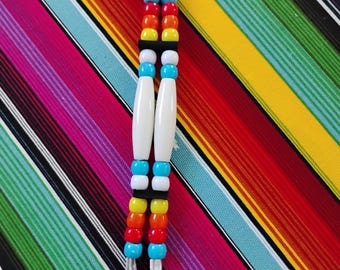 May include: A keychain featuring two parallel strands of colorful beads attached to a silver metal ring. The beads are arranged in a repeating pattern of turquoise, red, orange, yellow, and white, including two long white cylindrical beads.