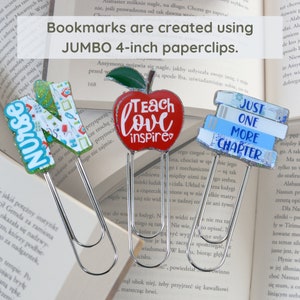 Op de afbeelding: Drie kleurrijke bladwijzers gemaakt van jumbo paperclips van 10 cm. De bladwijzers tonen een rode appel met de woorden "Teach Love Inspire", een stapel blauwe boeken met de woorden "Just One More Chapter", en een kleurrijke letter "N" met het woord "Nurse".