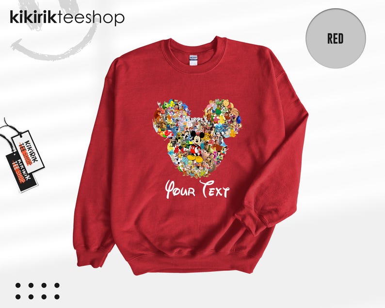 Pu&ograve; includere: Una felpa rossa con un disegno della testa di Topolino composto da vari personaggi dei cartoni animati. Le parole "Your Text" sono scritte in bianco sotto. La felpa ha maniche lunghe e girocollo.