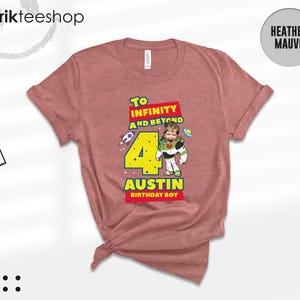 Puede incluir: Una camiseta de color malva jaspeado con un estampado gr&aacute;fico que incluye el texto To INFINITY AND BEYOND, el n&uacute;mero 4 y el nombre AUSTIN BIRTHDAY BOY. El dise&ntilde;o muestra un personaje de ranger espacial con cara de ni&ntilde;o y un cohete.
