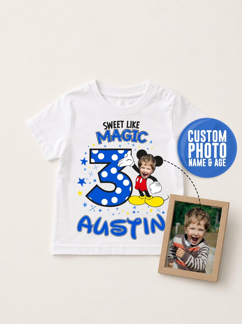 May include: A white short-sleeved t-shirt featuring a graphic of a cartoon mouse with a child's face, the number 3, and the text "SWEET LIKE MAGIC" and "AUSTIN". A small wooden frame displays a photograph of the child used in the graphic design.