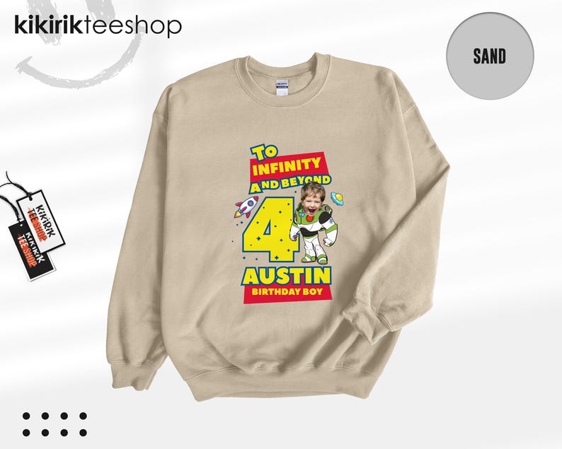 Puede incluir: Una sudadera de cuello redondo color arena con un estampado gr&aacute;fico que incluye el texto To Infinity and Beyond, el n&uacute;mero 4 y el nombre Austin. El dise&ntilde;o muestra un personaje de guardi&aacute;n espacial con cara de ni&ntilde;o y un cohete.