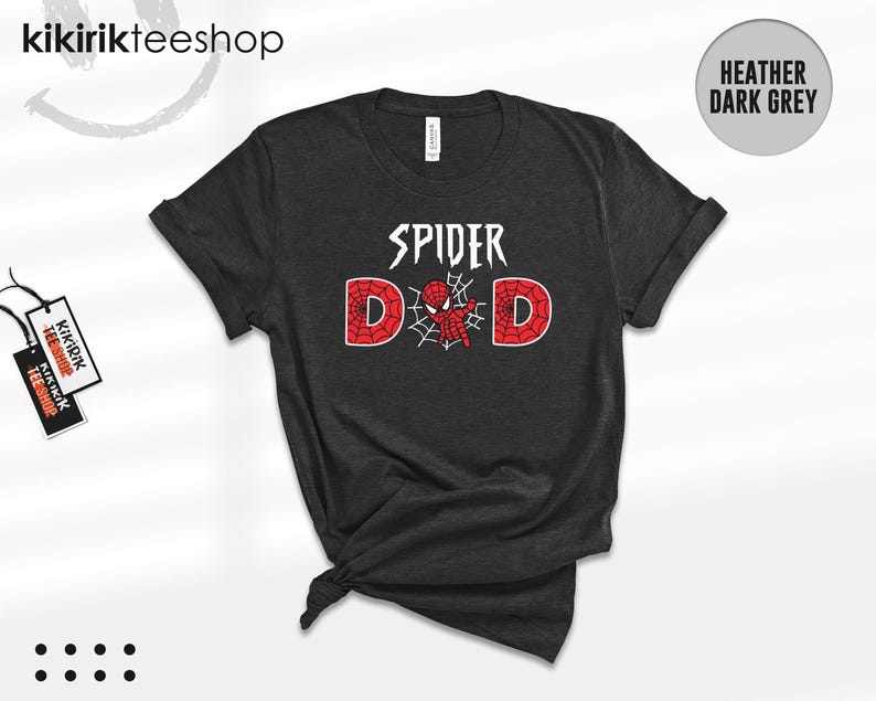 May include: A heather dark grey short-sleeve t-shirt featuring the white text SPIDER above the word DAD, where the letter A is replaced by a red and black spider-themed graphic with a web design inside the letters D and D.
