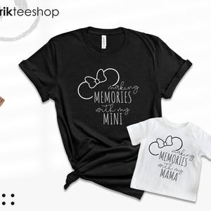 K&ouml;nnte beinhalten: Zwei schwarz-wei&szlig;e T-Shirts mit einem Mickey-Mouse-Ohren-Design und dem Text "Making Memories with my Mini" und "Making Memories with my Mama".