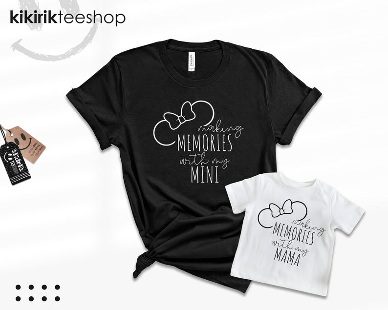 K&ouml;nnte beinhalten: Zwei schwarz-wei&szlig;e T-Shirts mit einem Mickey-Mouse-Ohren-Design und dem Text "Making Memories with my Mini" und "Making Memories with my Mama".