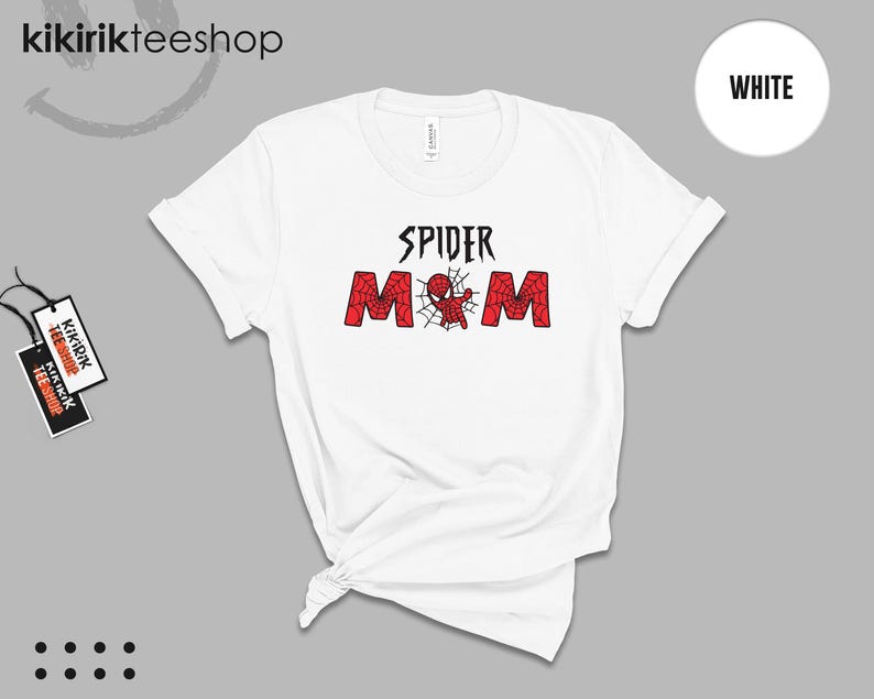 Puede incluir: Camiseta blanca con el texto "SPIDER MOM" en negro y rojo, con un dise&ntilde;o de Spider-Man. La camiseta tiene cuello redondo y mangas enrolladas. La marca "kikirikteeshop" es visible en la parte superior izquierda.