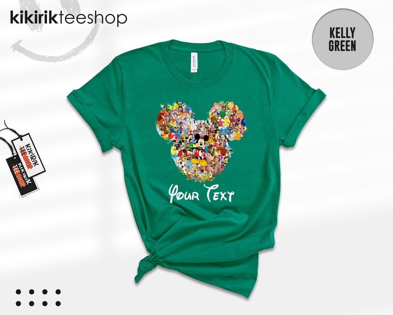 Pu&ograve; includere: T-shirt verde Kelly con un design a forma di testa di Topolino riempito con vari personaggi dei cartoni animati. Le parole "Your Text" sono scritte in bianco sotto. La maglietta ha un girocollo e maniche corte.