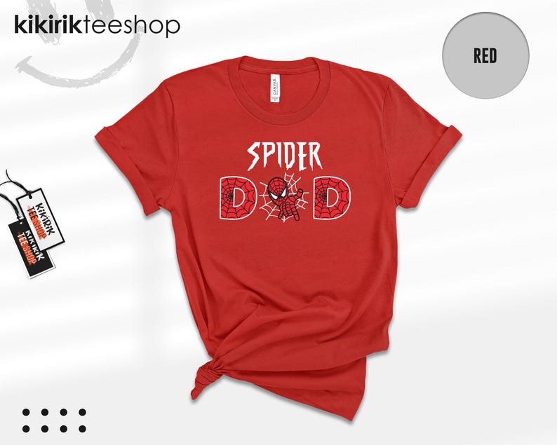 May include: A red short-sleeved t-shirt featuring the white text SPIDER DAD on the chest. The letter A is replaced by a small red and blue spider-themed character, and the two D letters are filled with a red and white spiderweb pattern design.