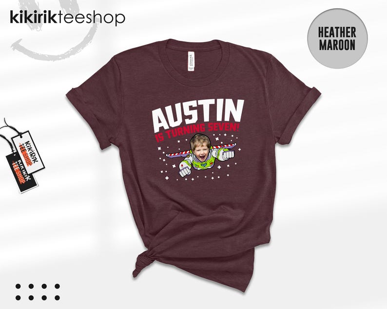 K&ouml;nnte beinhalten: Ein heather-maroonfarbenes T-Shirt mit dem wei&szlig;en Schriftzug AUSTIN und dem roten Text IS TURNING SEVEN! &uuml;ber einer Grafik eines Kindergesichts auf einem Weltraum-Ranger-Anzug mit Fl&uuml;geln, umgeben von kleinen wei&szlig;en Sternen auf dunklem Grund.