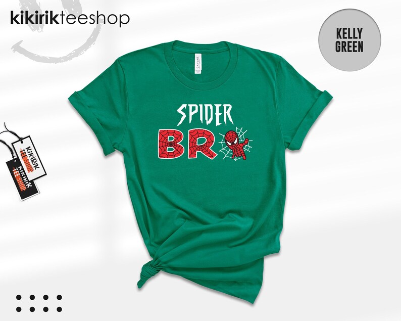 May include: A kelly green short-sleeve t-shirt featuring the white text SPIDER and the red, web-patterned text BRO, with a small red and blue spider-themed character graphic and a white spiderweb design positioned next to the letter O.