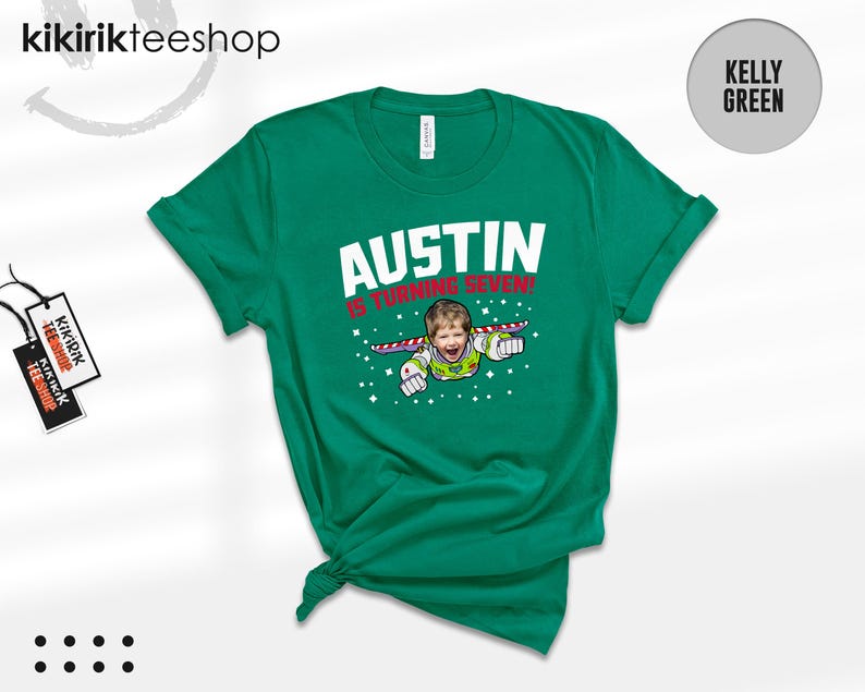 K&ouml;nnte beinhalten: Ein kellygr&uuml;nes Kurzarm-T-Shirt mit einer Grafik eines Kindes, das als Weltraum-Ranger verkleidet ist und mit Fl&uuml;geln fliegt. Der Text AUSTIN IS TURNING SEVEN! steht in wei&szlig;en und roten Buchstaben, umgeben von kleinen wei&szlig;en Sternen auf der Vorderseite.