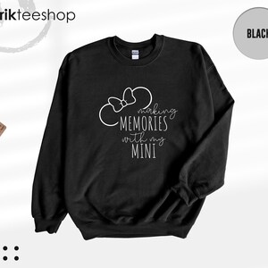 K&ouml;nnte beinhalten: Schwarzer Pullover mit wei&szlig;em Text, der "Making Memories with my Mini" lautet, und einer wei&szlig;en Umrandung von Mickey Mouse Ohren mit einer Schleife.
