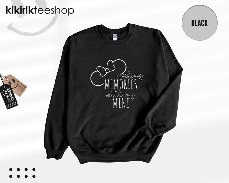 K&ouml;nnte beinhalten: Schwarzer Pullover mit wei&szlig;em Text, der "Making Memories with my Mini" lautet, und einer wei&szlig;en Umrandung von Mickey Mouse Ohren mit einer Schleife.