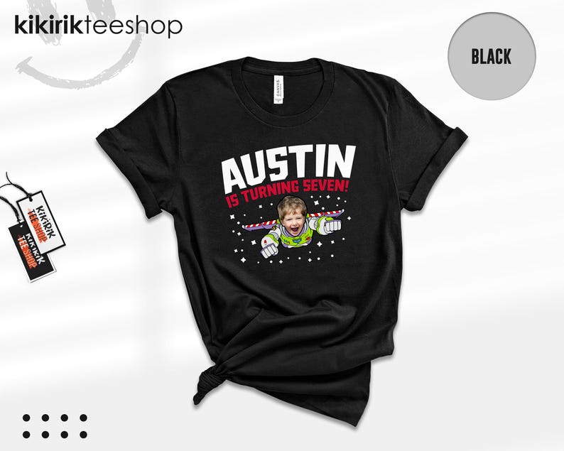 K&ouml;nnte beinhalten: Ein schwarzes Kurzarm-T-Shirt mit einer Grafik, die das Gesicht eines Kindes auf einem Weltraum-Ranger-Anzug zeigt. Der Text AUSTIN IS TURNING SEVEN! ist in wei&szlig;er und roter Schrift gehalten, umgeben von kleinen wei&szlig;en Sternen.