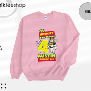Puede incluir: Una sudadera de cuello redondo rosa claro con un estampado gr&aacute;fico que incluye el texto To Infinity and Beyond, el n&uacute;mero 4 y el nombre Austin Birthday Boy. El dise&ntilde;o muestra un personaje de guardi&aacute;n espacial con cara de ni&ntilde;o.
