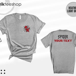 May include: A heather light grey short-sleeve t-shirt featuring a small Spider-Man graphic on the front left chest. The back of the shirt displays the text SPIDER in black and YOUR TEXT in red. The shirt is shown from both front and back views.