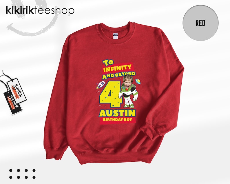Puede incluir: Una sudadera roja de cuello redondo con un estampado gr&aacute;fico que incluye el texto To INFINITY AND BEYOND, el n&uacute;mero 4 y el nombre AUSTIN BIRTHDAY BOY. El dise&ntilde;o muestra un personaje de guardi&aacute;n espacial con cara de ni&ntilde;o y cohetes peque&ntilde;os.