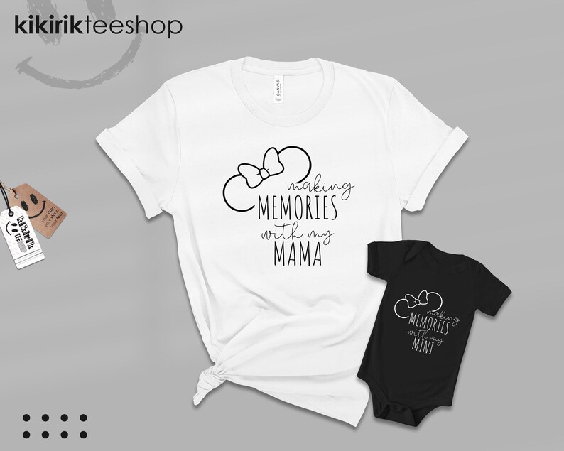 K&ouml;nnte beinhalten: Zwei wei&szlig;e T-Shirts mit schwarzem Text und einer schwarzen Schleife. Das gr&ouml;&szlig;ere Shirt sagt "Making Memories with my Mama". Das kleinere Shirt sagt "Making Memories with my Mini".