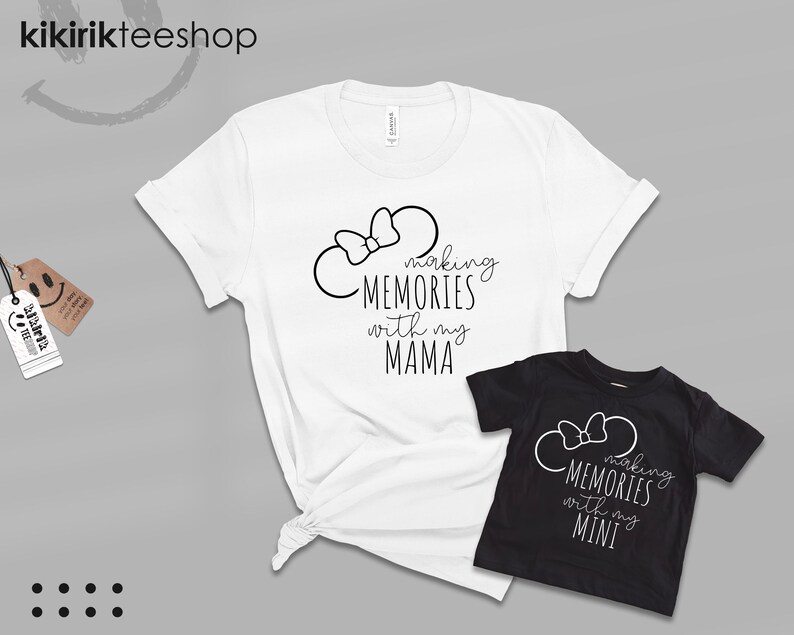 K&ouml;nnte beinhalten: Zwei wei&szlig;e T-Shirts mit schwarzem Text und einer schwarzen Schleife. Das gr&ouml;&szlig;ere Shirt sagt "Making Memories with my Mama" und das kleinere Shirt sagt "Making Memories with my Mini".