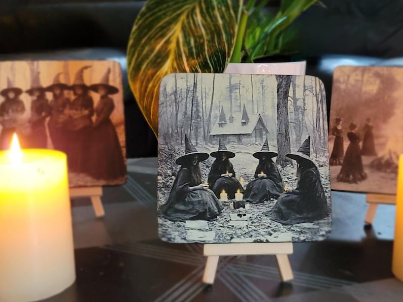 Puede incluir: Piezas de arte de madera con im&aacute;genes vintage de brujas con sombreros puntiagudos. Una muestra brujas en un bosque, otra representa un grupo de brujas de pie juntas. Velas encendidas en primer plano crean un ambiente m&iacute;stico.