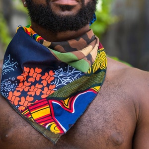 May include: A multi-colored bandana with a blue, green, orange, and yellow pattern. The bandana is tied around a person's neck.