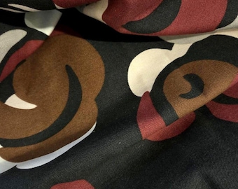 Puede incluir: Primer plano de una tela con un estampado floral repetido. El diseño presenta grandes formas de flores abstractas en tonos marrón, burdeos, negro, blanco y gris sobre un fondo negro. La tela parece suave y ligeramente texturizada.