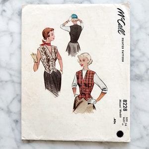 May include: Vintage McCall's sewing pattern for a women's vest, size 14, bust 32. The pattern shows three different styles of vests, one with a leopard print, one with a plaid pattern, and one with a solid color. The pattern is printed on white paper with black text.