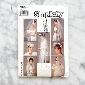May include: A Simplicity sewing pattern for a bridal veil, with illustrations of different veil styles and headpieces. The pattern number is 8509 and the size is one size.