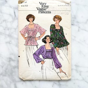 Peut inclure: Patron de couture Vogue Patterns vintage, taille 10. Le patron présente des illustrations de trois chemisiers différents avec des encolures carrées et des manches longues. La couverture du patron est blanc cassé avec le texte "Very Easy Vogue Patterns".