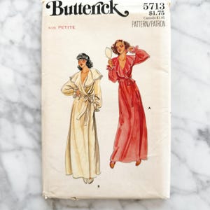 May include: Vintage sewing pattern for a women's robe. The pattern is from Butterick and is size petite. The pattern number is 5713 and the price is $1.75. The pattern shows two women wearing different versions of the robe, one in white and one in red.