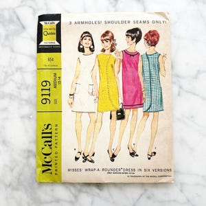 May include: Vintage McCall's 9119 sewing pattern for a wrap-around dress in six versions. The pattern is for sizes 12-14 and is titled "Misses' Wrap-A-Rounder Dress in Six Versions".
