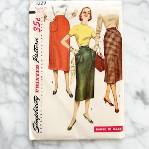 May include: Vintage Simplicity sewing pattern number 1229 for a skirt. The pattern is printed on a white background with a red, green, and black and white checked skirt. The pattern is for a size 27 waist and 36 hip. The pattern is 35 pence.