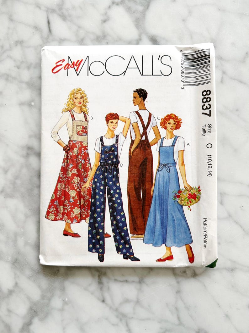 May include: A sewing pattern for a jumpsuit with three different styles. The pattern is for sizes 10, 12, and 14. The pattern is from McCall's and is called "Easy McCall's" and the pattern number is 8837.